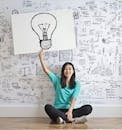 Woman Draw a Light bulb in White Board